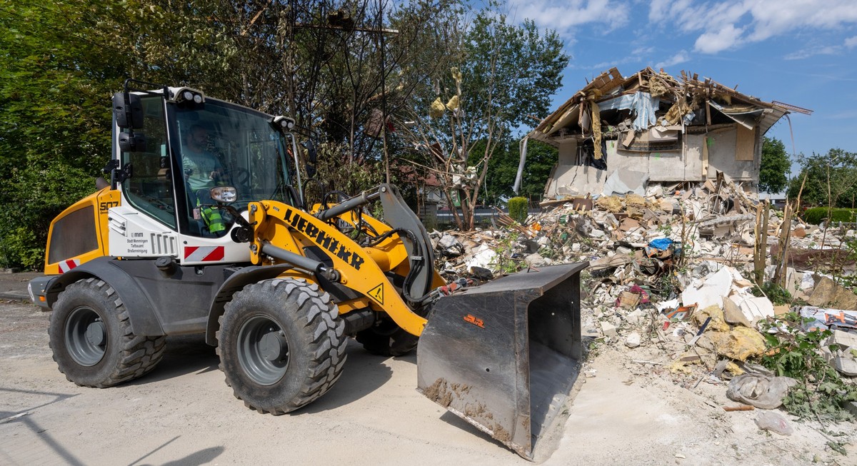 27.07.2024, Bayern, Memmingen: Mit einem Radlader werden Trümmer beseitigt. Am Freitagnachmittag kam es zu einer Explosion, bei der ein Haus komplett zerstört und ein Mensch getötet wurden. Foto: Stef ...