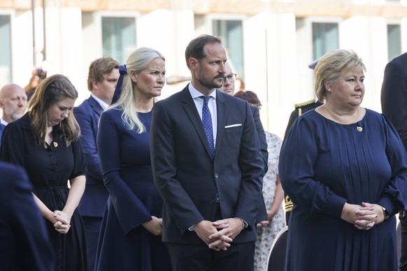 22.07.2021, Norwegen, Oslo: Kronprinzessin Mette-Marit (2.v.l-r) von Norwegen, Kronprinz Haakon Magnus (M-r) von Norwegen, und Erna Solberg, Ministerpr�sidentin von Norwegen, nehmen an einer Gedenkfei ...