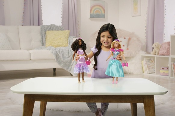 This image released by Mattel shows a child playing with Teresa, a My First Barbie deluxe set, new dolls made specifically for children as young as 3. They are 13.5 inches tall, with a broader waste t ...