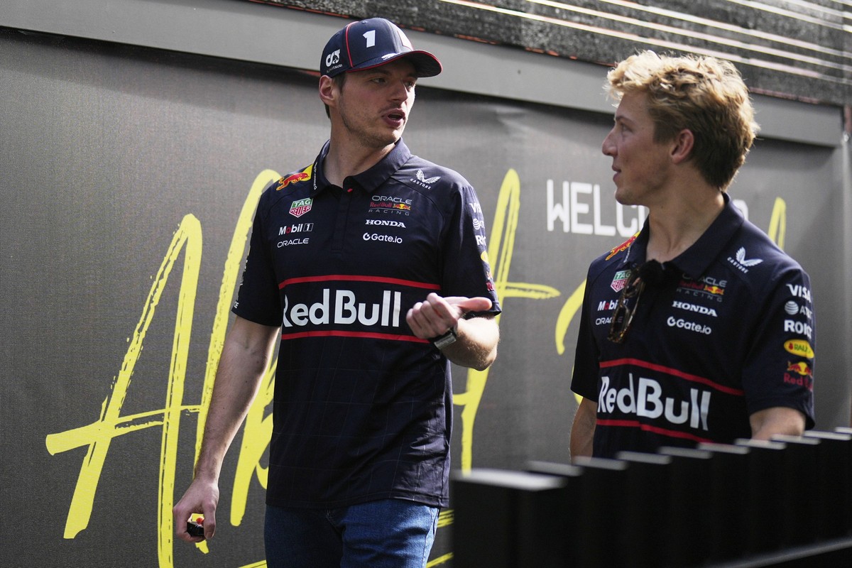 Red Bull driver Max Verstappen, left, of the Netherlands walks with teammate Liam Lawson of New Zealand as they arrive at the Australian Formula One Grand Prix at Albert Park, in Melbourne, Australia, ...