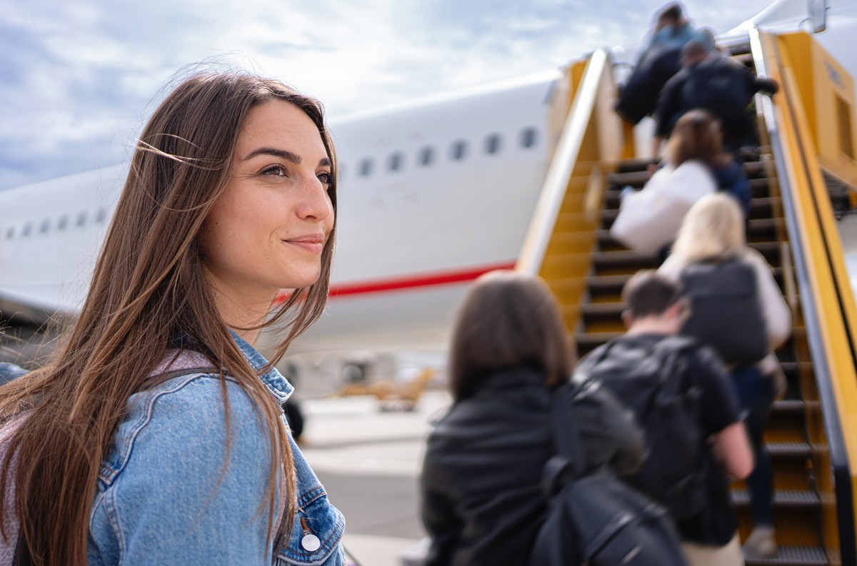 Close up of a young woman walking to the airplane to board her flight
