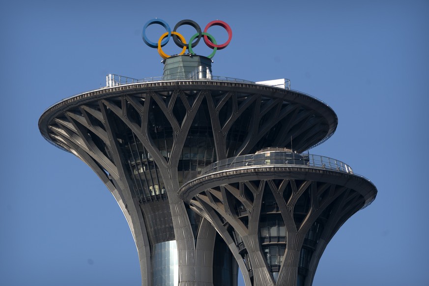 ARCHIV - 02.02.2021, China, Peking: Die olympischen Ringe sind auf der Spitze des Olympiaturms zu sehen. Die Olympischen Winterspiele Peking 2022 sollen am 4. Februar 2022 er