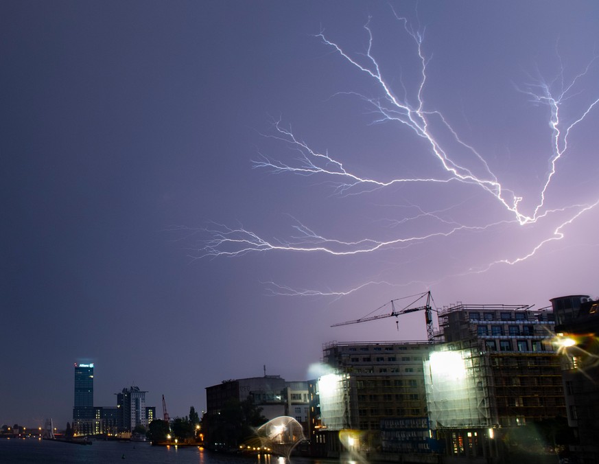11.06.2019, Berlin: Blitze zucken während eines Gewitters unweit des Allianz-Hochhauses über den Himmel. Foto: Paul Zinken/dpa +++ dpa-Bildfunk +++
