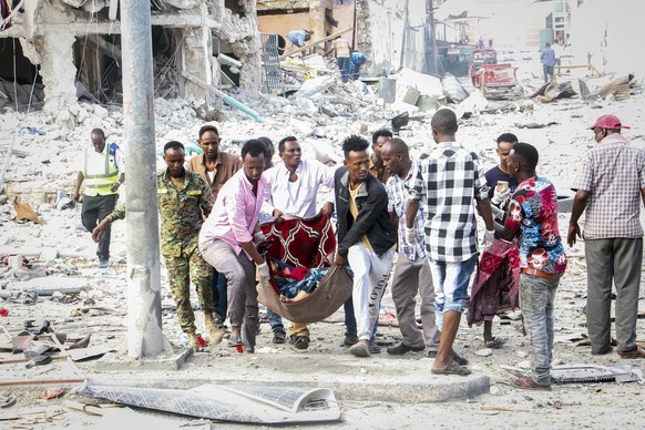 Rescuers remove a seriously-injured body from the scene of a double car-bomb attack in the capital Mogadishu, Somalia Saturday, Oct. 29, 2022. Two car bombs exploded Saturday at a busy junction in Som ...