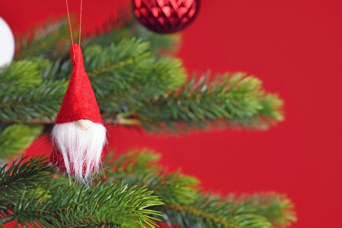 Geschmückter Weihnachtsbaum mit niedlichem Weihnachtswichtel-Baumschmuck auf rotem Hintergrund *** Geschmückter Christmas tree with cute Yuletide Lads Tree decorations at red Background Copyright: ima ...