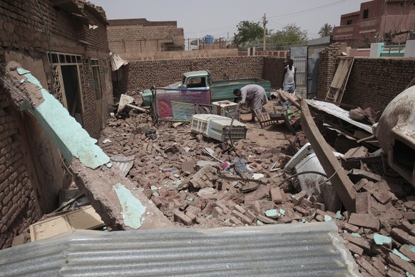 A man cleans debris of a house hit in recent fighting in Khartoum, Sudan, Tuesday, April 25, 2023. Sudan&#039;s warring generals have pledged to observe a new three-day truce that was brokered by the  ...