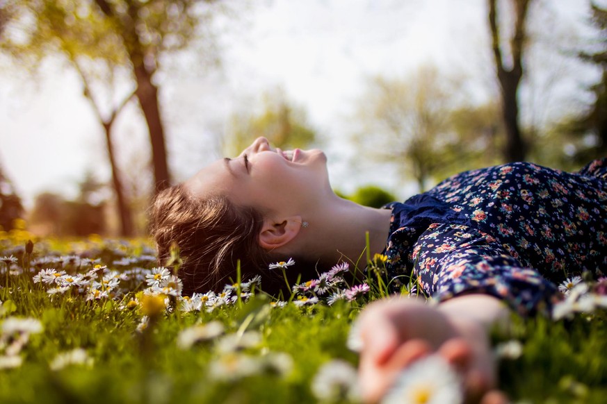 Pretty young teenage girl laying on a grass