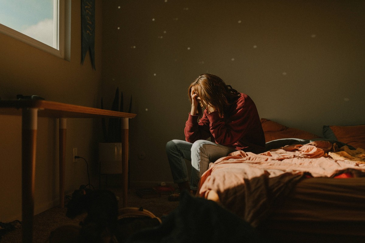 a woman with head in hands feeling anxiety and depression by window Los Angeles, California, United States CR_YFEU220404F8-938320-01 ,model released, Symbolfoto