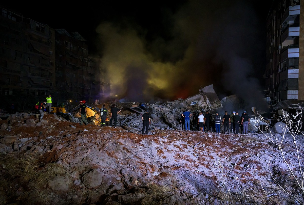 27.09.2024, Libanon, Beirut: Rettungskräfte versammeln sich nach einem israelischen Luftangriff auf das Hauptquartier der pro-iranischen Hisbollah, in den südlichen Vororten von Beirut. Foto: Marwan N ...