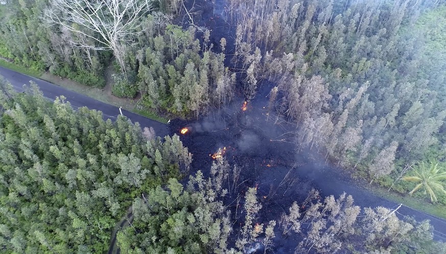 In this still frame taken from video, lava flows over a road in the Puna District as a result of the eruption from Kilauea Volcano on Hawaii&#039;s Big Island Friday, May 4, 2018. The eruption sent mo ...