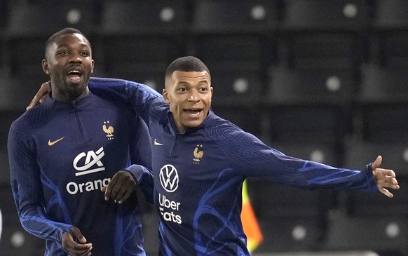 France&#039;s Kylian Mbappe, right, and Marcus Thuram, practise during a training session at the Jassim Bin Hamad stadium in Doha, Qatar, Friday, Dec. 16, 2022. France will play against Argentina duri ...