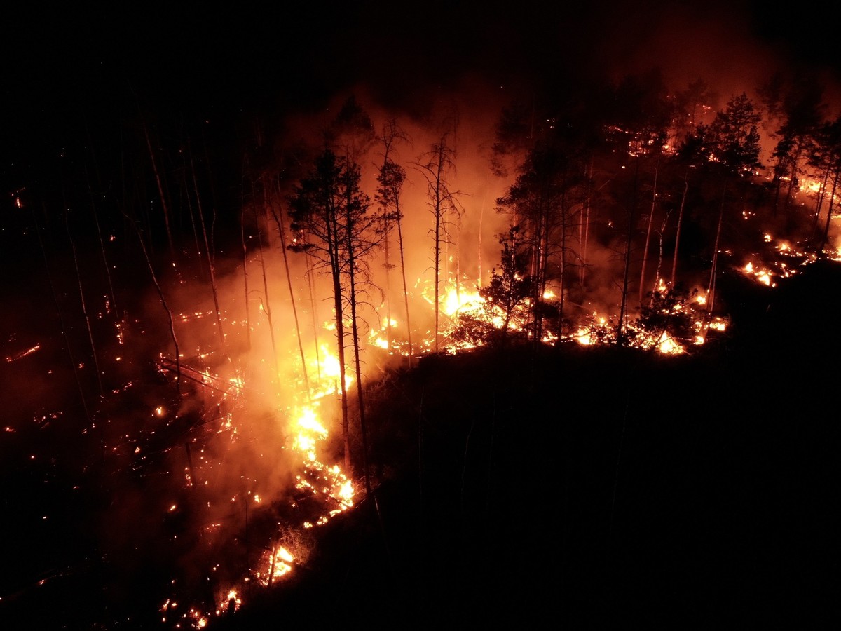 05.06.2023, Brandenburg, Jüterbog: Flammen schlagen bei Nacht in einem Waldstück nahe Jüterbog in die Höhe (Aufnahme mit Drohne). Auffrischender Wind hat den Waldbrand bei Jüterbog südlich von Berlin ...