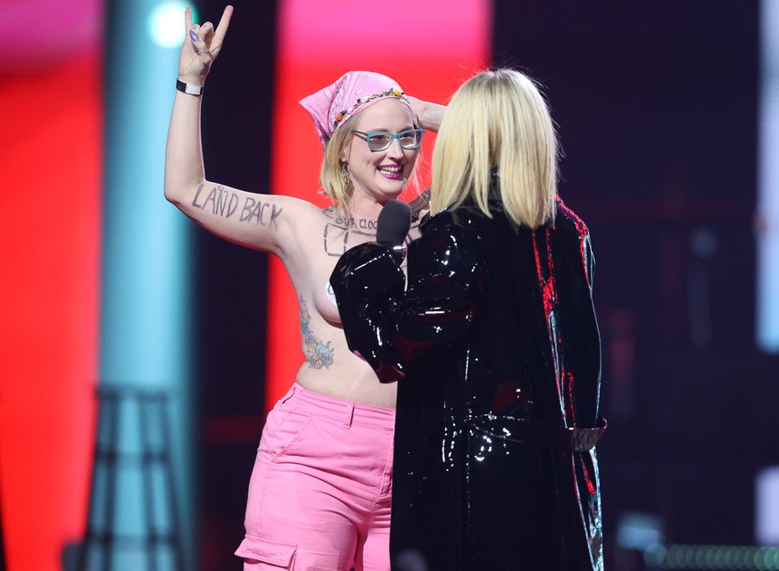Juno Awards in Edmonton - Nacktprotest bei Avril Lavigne Auftritt March 13, 2023, EDMONTON, AB, CANADA: Avril Lavigne confronts a topless protester as she presents during the Junos Monday, March 13, 2 ...
