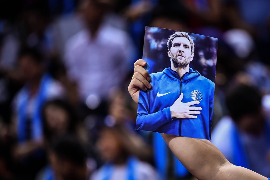 Sport Bilder des Tages A Chinese basektball fan shows a photo of Dirk Nowitzki of Dallas Mavericks as they compete against Philadelphia 76ers during the Shenzhen match of the NBA Basketball Herren USA ...