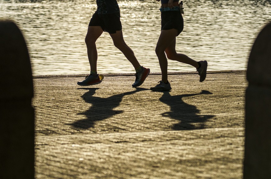 04.08.2022, Rheinland-Pfalz, Mainz: Zwei Menschen joggen in den fr