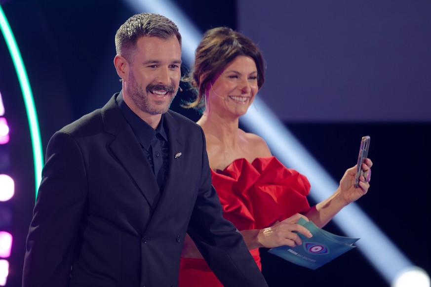 08.12.2022, Nordrhein-Westfalen, Köln: Die Moderatoren Jochen Schropp und Marlene Lufen stehen beim Finale der Reality-Show &quot;Promi Big Brother&quot; im Studio im Sat.1 Fernsehen. Foto: Henning Ka ...