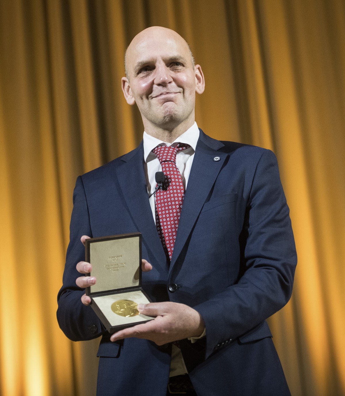 ARCHIV - 07.12.2021, Berlin: Der deutsche Chemiker Benjamin List, der den Nobelpreis f�r Chemie 2021 bekommen hat, zeigt seine Medaille. Die Nobelpreisverleihung 2021 findet aufgrund der Coronavirus-P ...