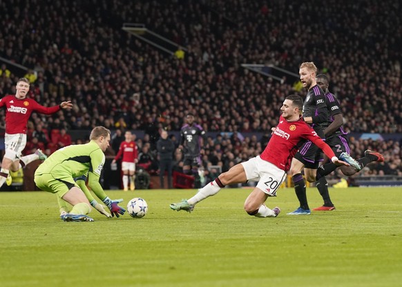 Manchester, England, 12th December 2023. Manuel Neuer of Bayern Munichcollects from a lunging Diogo Dalot of Manchester United, ManU during the UEFA Champions League match at Old Trafford, Manchester. ...