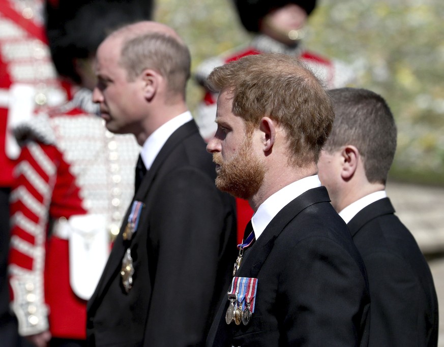 Britain&#039;s Prince William, left, and Prince Harry follow the coffin as it slowly makes its way in a ceremonial procession during the funeral of Britain&#039;s Prince Philip inside Windsor Castle i ...