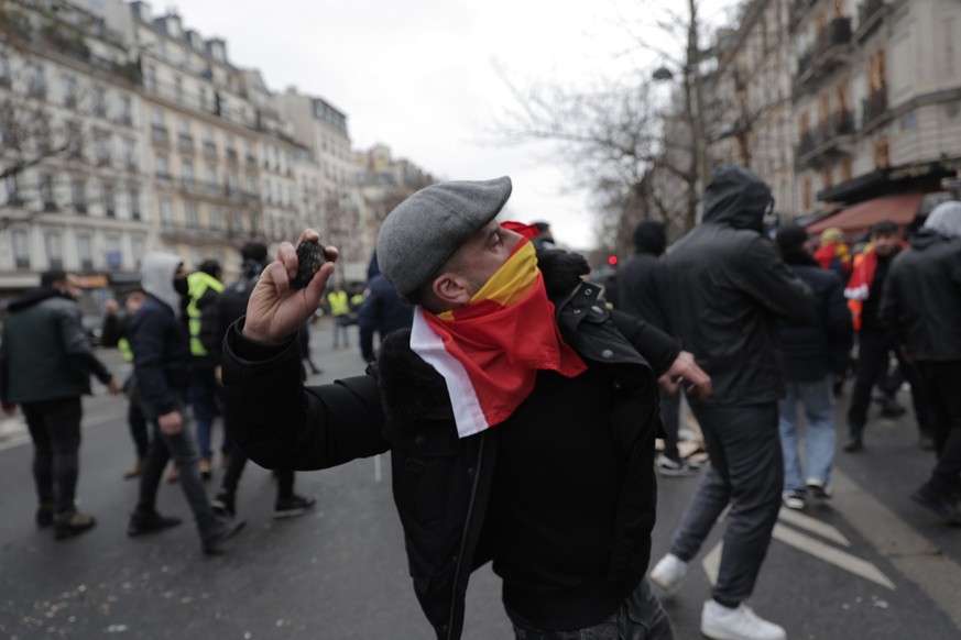 A demonstrator throw a stone during a protest against the recent shooting at the Kurdish culture center in Paris, Saturday, Dec. 24, 2022. Kurdish activists, left-wing politicians and anti-racism grou ...