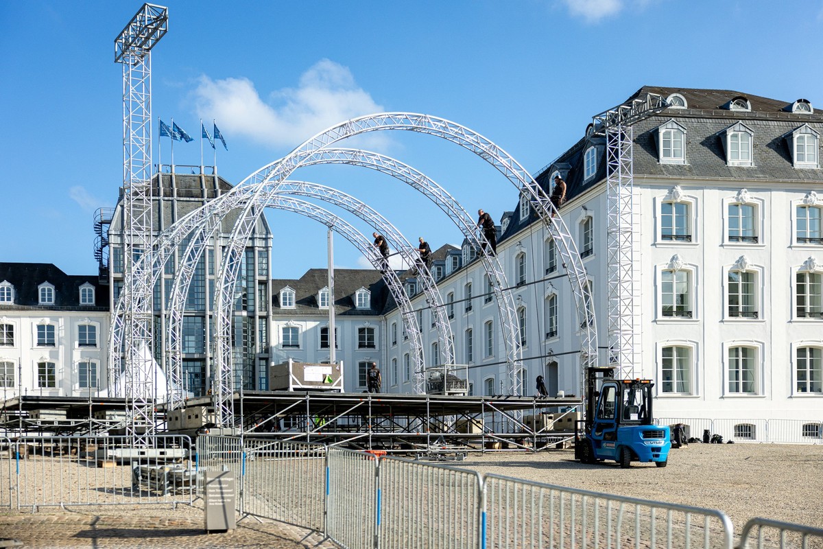 29.09.2025, Saarland, Saarbrücken: Arbeiter mit Kletterausrüstung bauen vor dem Saarbrücker Schloss eine riesige Bühne für die Feierlichkeiten zum Tag der Deutschen Einheit am 3. Oktober auf. Foto: La ...