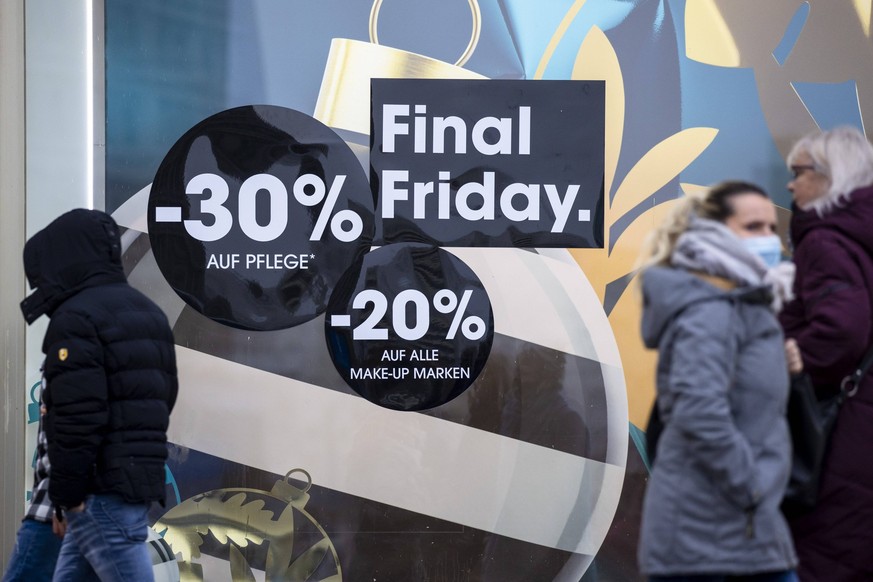 Menschen laufen vor einer Vitrine mit Rabattwerbung wahrend Black Friday in Berlin am 27. November 2020. Black Week und Weihnachtshopping in Berlin *** People walking in front of a display case with d ...