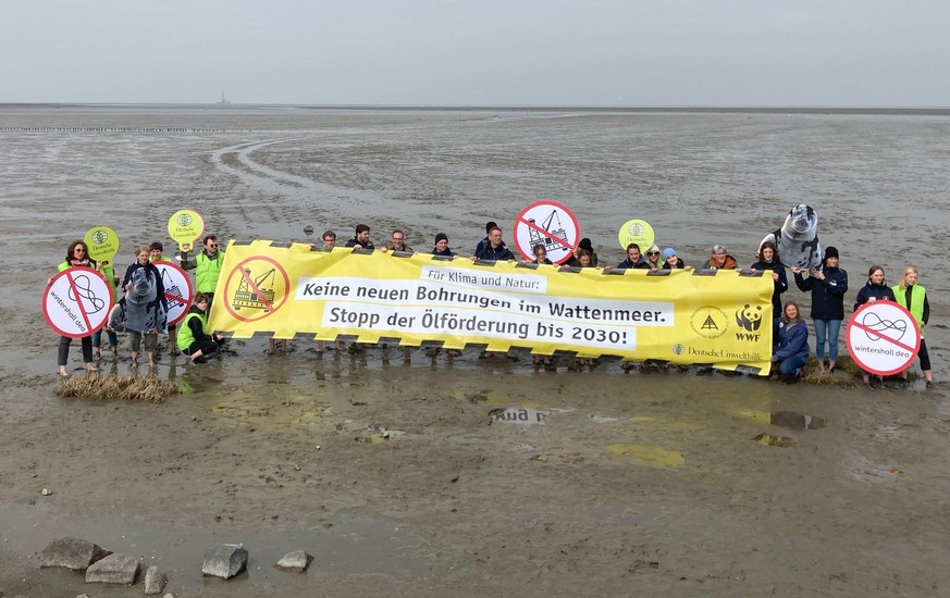 Teilnehmer einer Aktion mehrerer Umweltverbände gehen die Ölförderung im Wattenmeer halten ein Banner mit der Aufschrift &quot;Keine neuen Bohrungen im Wattenmeer. Stopp der Ölförderung bis 2030!&quot ...
