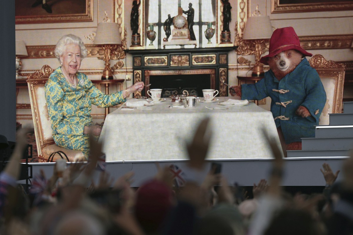 04.06.2022, Gro�britannien, London: Die Zuschauer sehen auf einer gro�en Leinwand w�hrend der Platin-Party vor dem Buckingham Palast am dritten Tag der Platin-Jubil�umsfeierlichkeiten f�r K�nigin Eliz ...