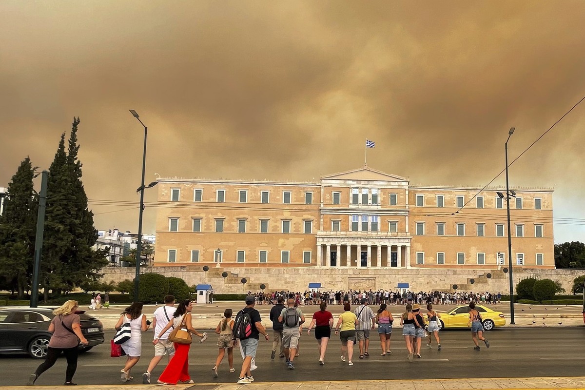 11.08.2024, Griechenland, Athen: Rauch von Waldbränden ist über dem griechischen Parlamentsgebäude im Stadtzentrum zu sehen, nachdem ein Brand nordöstlich der Hauptstadt zu Evakuierungen geführt hat.  ...
