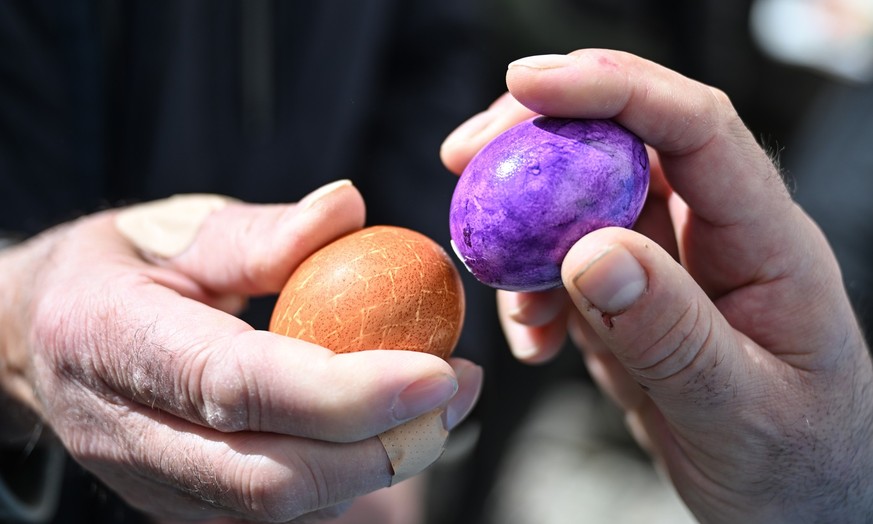 10.04.2023, Baden-Württemberg, Leutkirch In Allgäu: Gemeindemitglieder kämpfen am Ostermontag nach dem Gottesdienst vor der evangelischen Stadtkirche um das härteste Osterei. Dutzende beteiligen sich  ...