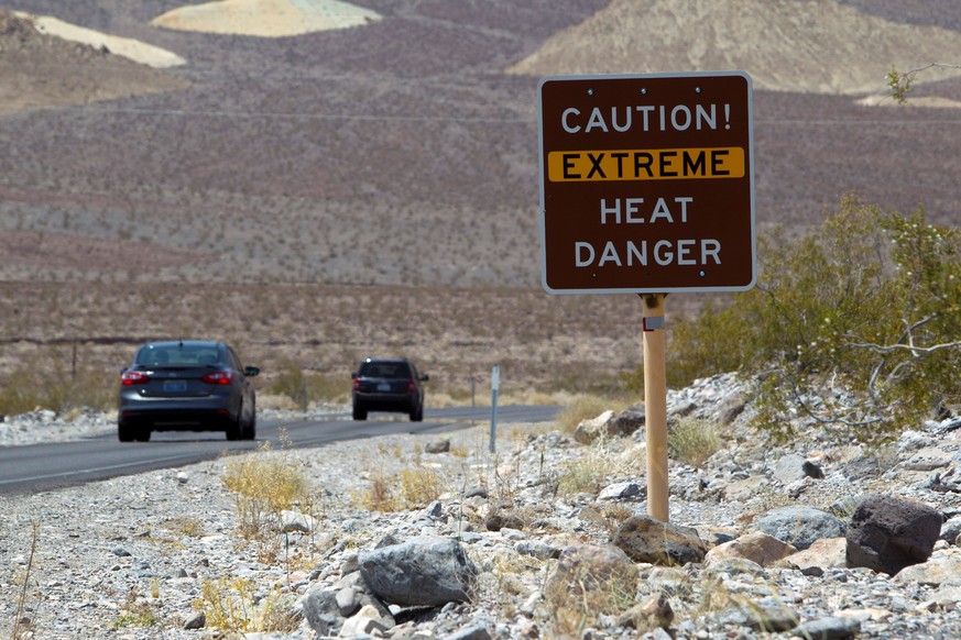 FILE PHOTO: A sign warns of extreme heat as tourists enter Death Valley National Park in California June 29, 2013. REUTERS/Steve Marcus/File Photo