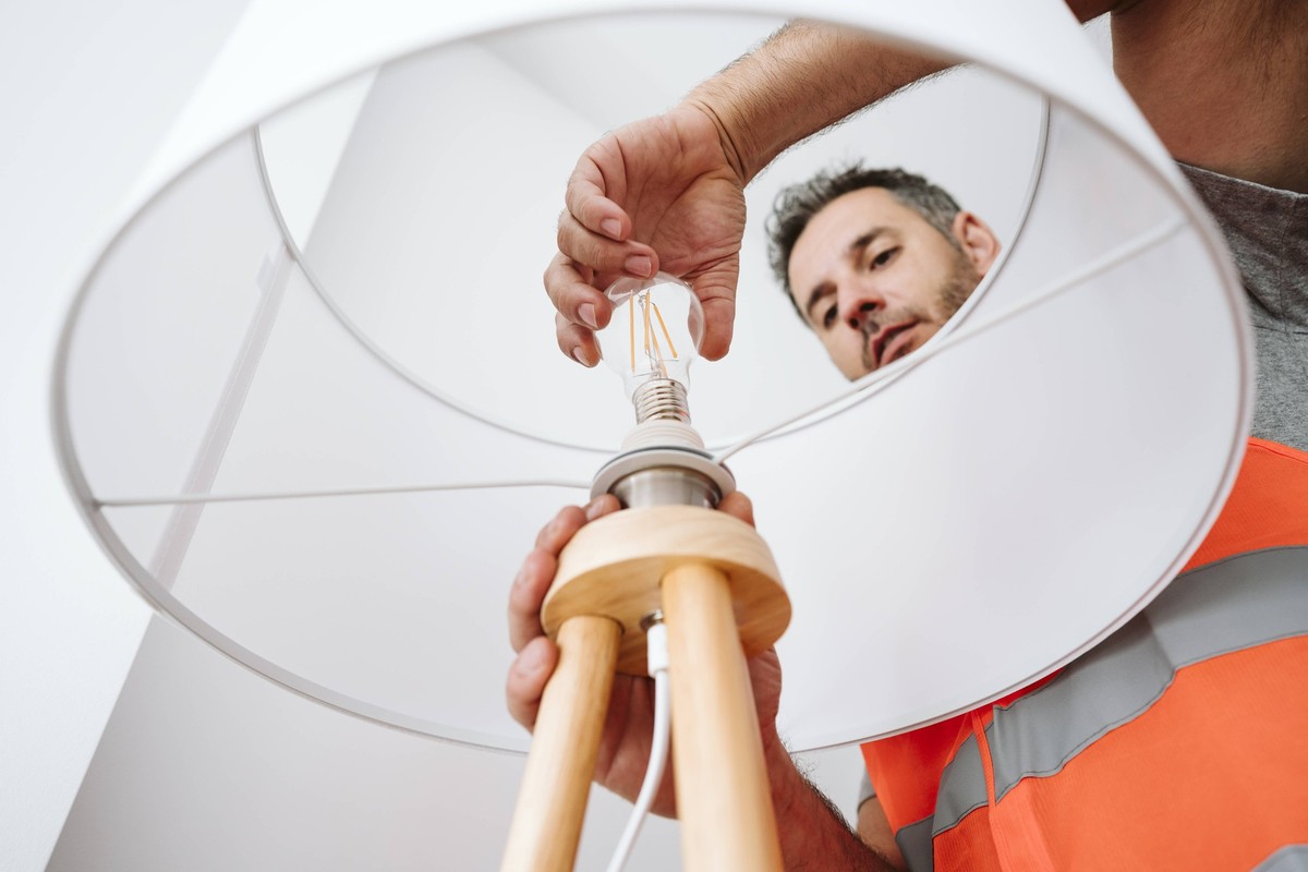 Electrician installing light bulb in lamp shade at home model released, Symbolfoto property released, EBBF08609