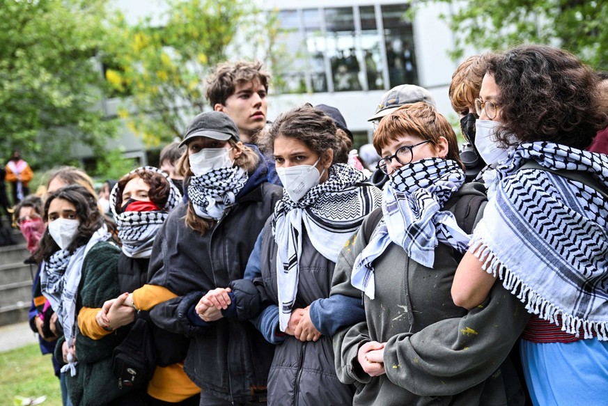 Pro-Palestinian demonstrators form a human chain as they occupy a courtyard at Freie Universitat (FU) Berlin with a protest camp, amid the ongoing conflict between Israel and Palestinian Islamist grou ...
