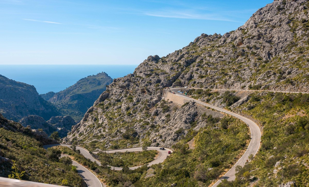 Berglandschaft mit sich windender Bergstra�e von Sa Calobra zum Torrent de Pareis, Autos und ein Radfahrer auf Serpentinen mit diversen Kehren, Haarnadelkurven, Haarnadelkehren, Spitzkehren, steile, t ...