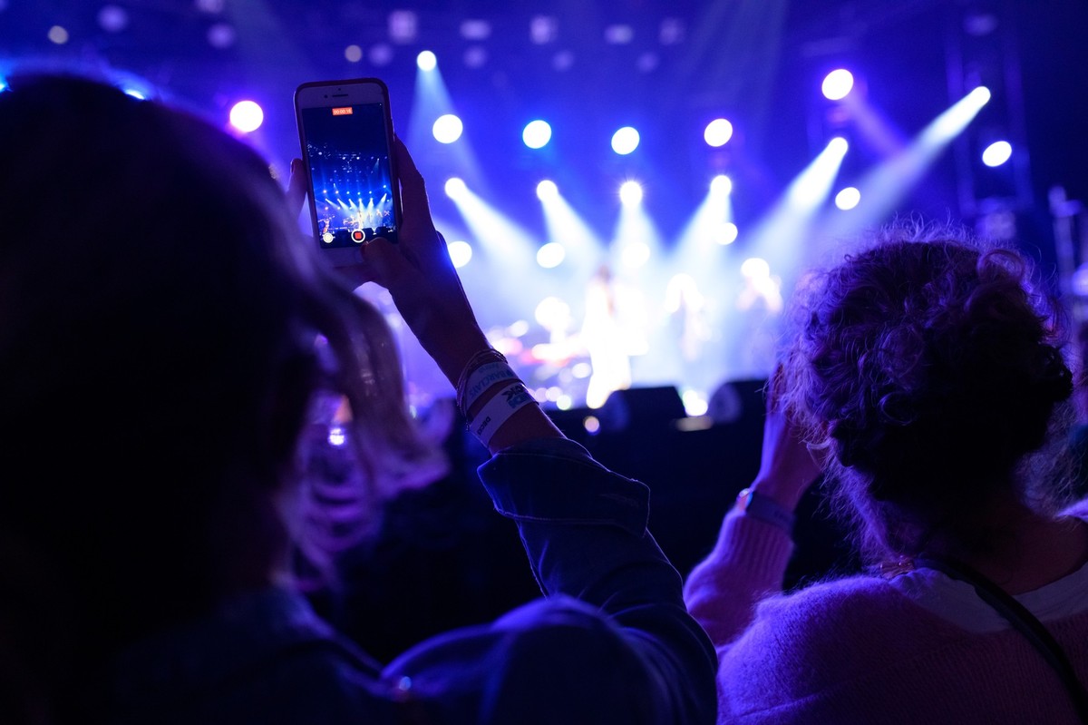 ARCHIV - 14.12.2021, Hamburg: Eine Zuschauerin filmt vor der B�hne mit ihrem Handy. (zu dpa: �S�chsischer Popmusik-Wettbewerb gestartet - 70 000 Euro Preisgeld�) Foto: Jonas Walzberg/dpa +++ dpa-Bildf ...