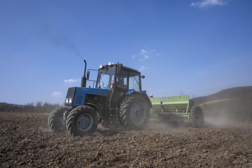 26.03.2022, Ukraine, Husakiw: Arbeiter pfl�gen ein Weizenfeld im Westen der Ukraine. In der Ukraine hat die Aussaat- und Pflanzsaison begonnen. Auf die Ukraine und Russland entf�llt ein Drittel der we ...