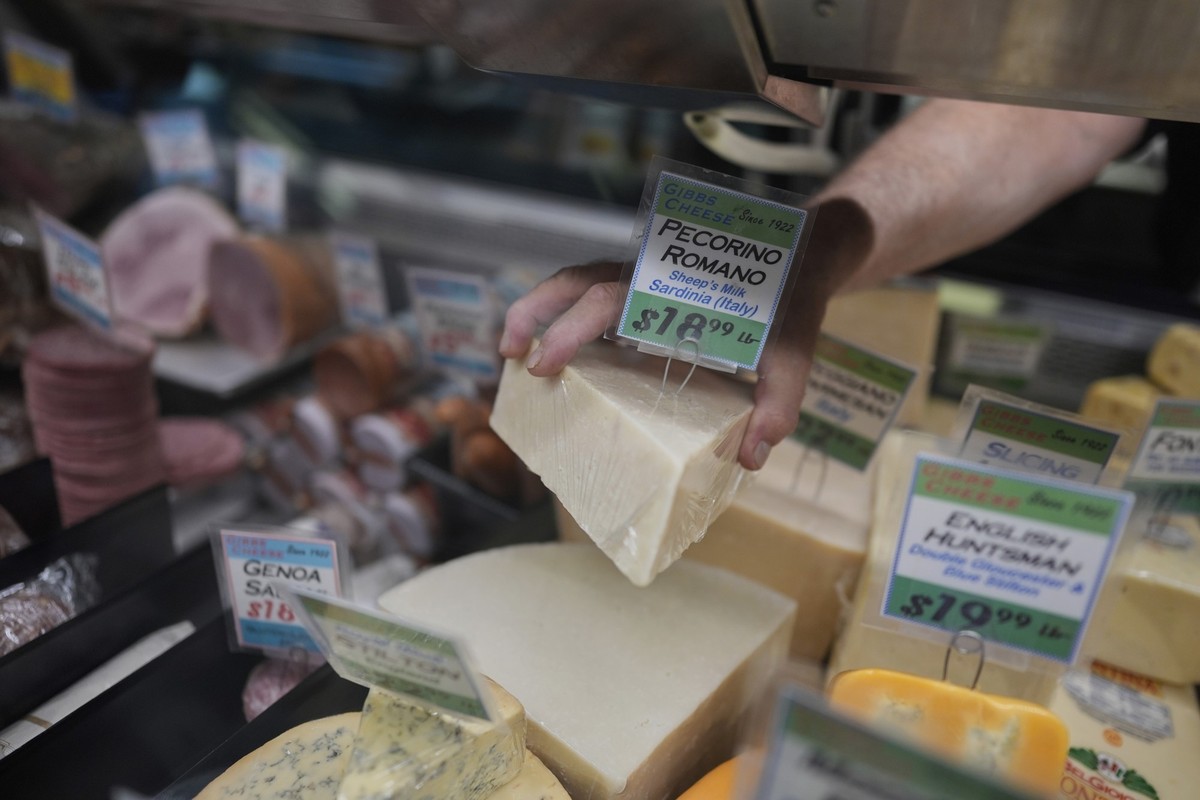 03.04.2025, USA, Cincinnati: Jeff Gibbs, Inhaber von Gibbs Cheese, greift in seinem Geschäft im Findlay Market nach einem aus Sardinien importierten Pecorino Romano-Käse. Foto: Carolyn Kaster/AP/dpa + ...