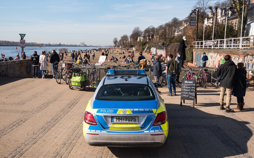 21.02.2021, Hamburg: Ein Streifenwagen der Polizei parkt am Zugang zum Elbstrand