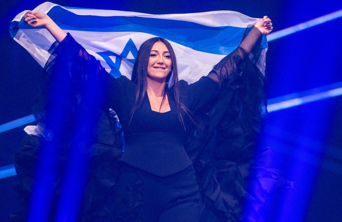 ARCHIV - 16.05.2025, Schweiz, Basel: Yuval Raphael aus Israel kommt mit der Landesfahne bei einer Probe für die Finalshow des 69. Eurovision Song Contest in der Arena St. Jakobshalle auf die Bühne. (z ...
