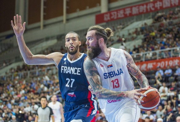 Miroslav Radulica of Serbia, right, keeps the ball while defended by Rudy Gobert-Bourgarel of France, left, during the final of 2019 International Basketball Championship in Shenyang city, northeast C ...