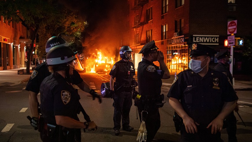 200530 Police in front of a police car that has been set one fire during a protest over the death of George Floyd, on May 30, 2020 close to Union Square in the Manhattan borough of New York, NY, USA.  ...
