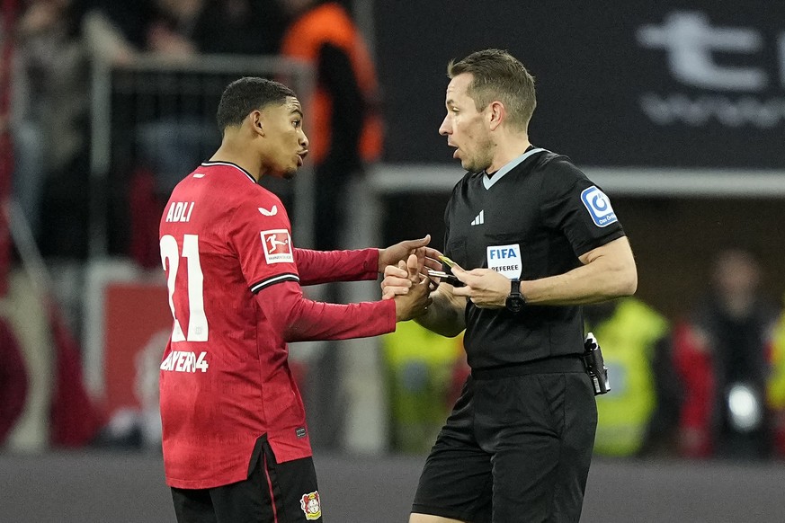 Leverkusen&#039;s Amine Adli, left, speaks to the referee during the German Bundesliga soccer match between Bayer Leverkusen and Bayern Munich in Leverkusen, Germany, Sunday, March 19, 2023. (AP Photo ...