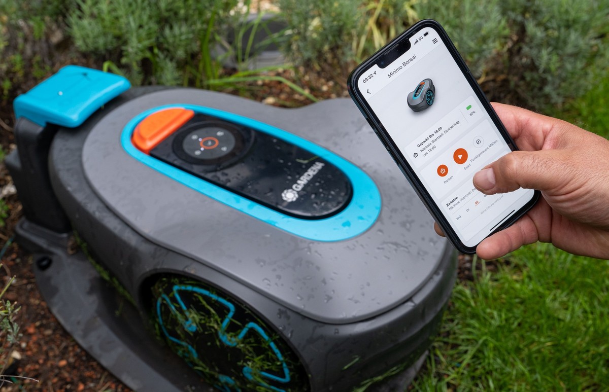 31.08.2022, Baden-Württemberg, Ulm: Ein Gardena-Mähroboter wird in seiner Basisstation mit einer App auf einem Smartphone gesteuert. Die auf Gartengeräte und Bewässerungssysteme spezialisierte Gardena ...