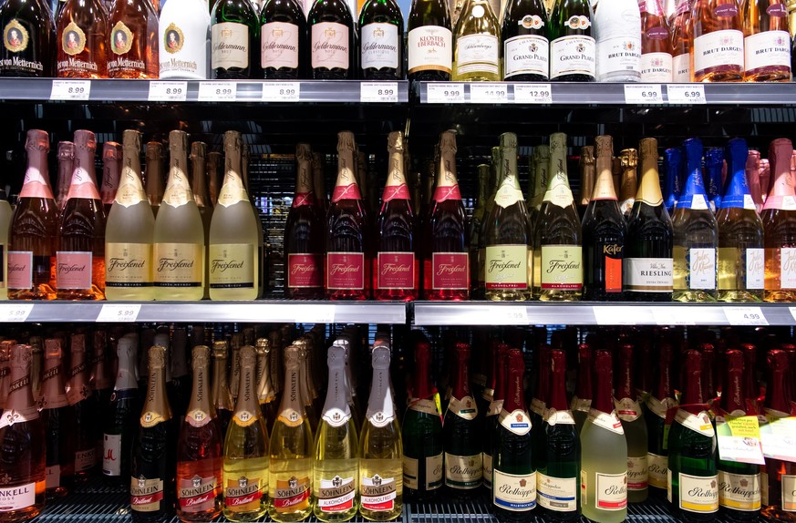ARCHIV - 13.03.2020, Bayern, Neubiberg: Sektflaschen von verschiedenen Herstellern stehen in einem Supermarktregal. (zu dpa ´Sekt ohne Folienkapsel - EU-Regelung ermˆglicht andere Flaschen ª) Foto: Sv ...
