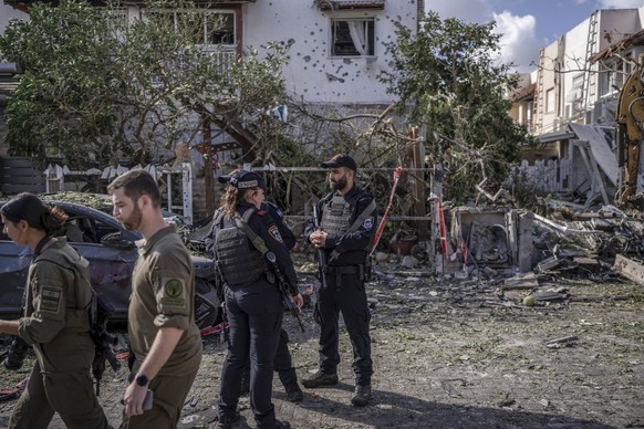 22.09.2024, Israel, Kirjat Bialik: Sicherheitskräfte stehen vor beschädigten Gebäuden nach einem angeblichen Angriff der pro-iranischen Hisbollah-Bewegung. Foto: Ilia Yefimovich/dpa +++ dpa-Bildfunk + ...