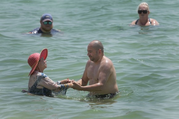 Beach goers bob in the water off of Hollywood Beach, Monday, July 10, 2023, in Hollywood, Fla. Water temperatures in the mid-90s (mid-30s Celsius) are threatening delicate coral reefs, depriving swimm ...