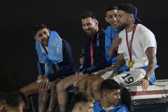 Leandro Paredes (v.l.), Lionel Messi, Ángel Di María und Nicolas Otamendi sitzen nachts auf dem Dach des Doppeldecker-Busses.