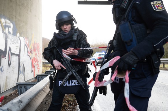 Polizeibeamte sperren die Kreisstraße 22 rund einen Kilometer von dem Tatort entfernt.