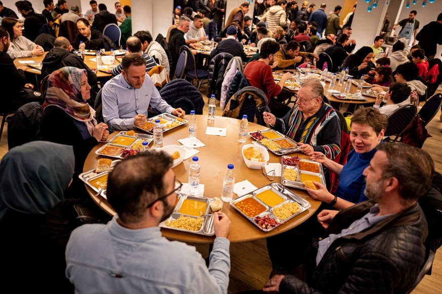 dpatopbilder - PRODUKTION - 23.03.2023, Berlin: Mitglieder der Gemeinde treffen sich nach dem Beginn des Fastenmonats Ramadan am Mittwochabend in der Sehitlik-Moschee zum ersten Iftar, dem Fastenbrech ...