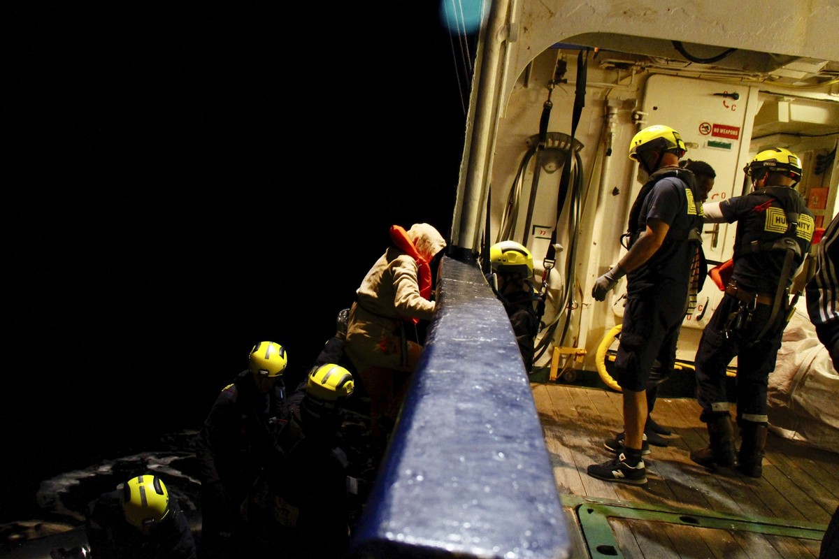 Migrants are helped to get aboard during rescue operation carried out by the crews of the ships Humanity 1 and Louise Michel in international waters off the Libyan coast, Sunday, Dec. 4, 2022. (Nicole ...